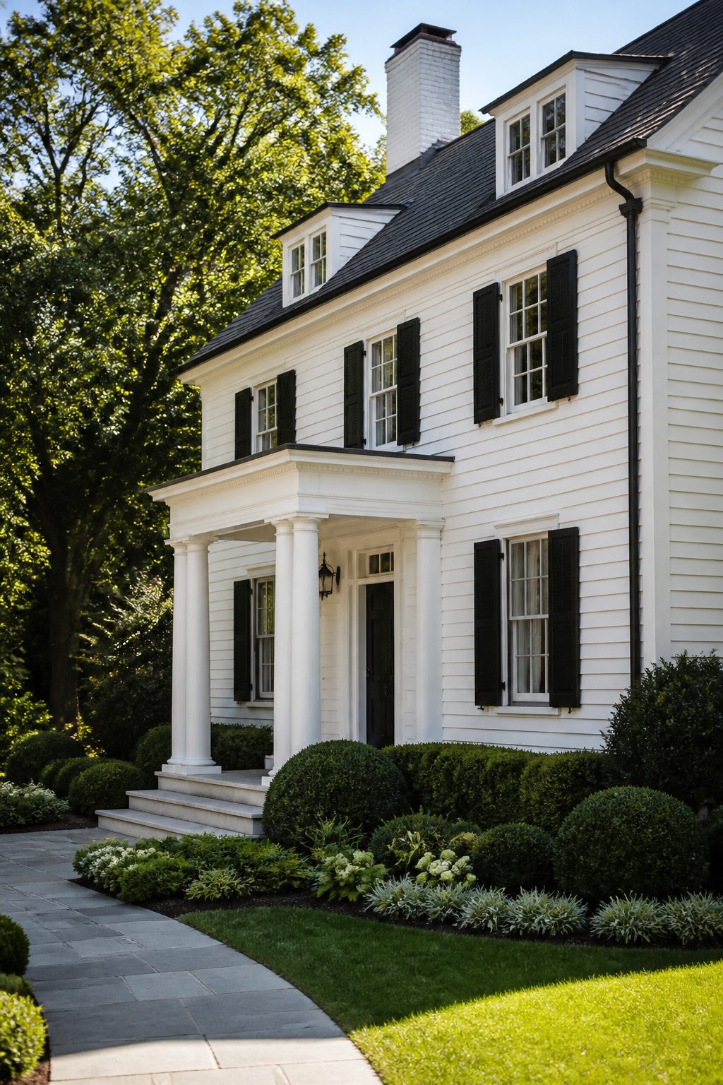 Colonial-style house featuring a warm white exterior and dark trim.
